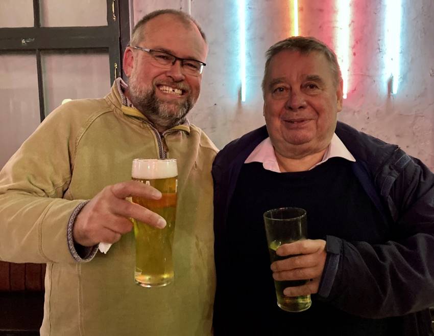 Two men holding glasses of beer

Description automatically generated with medium confidence