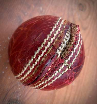 A red leather ball with white stitching

Description automatically generated