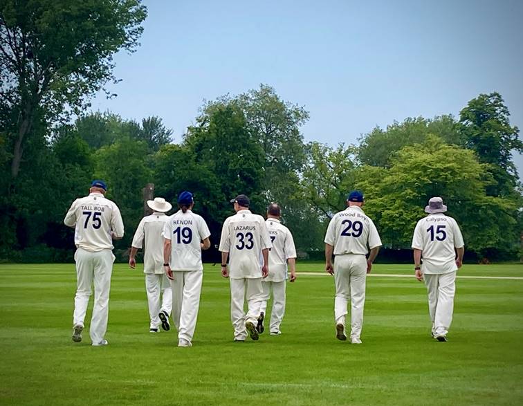 A group of men in white uniforms walking on a grass field

Description automatically generated with low confidence