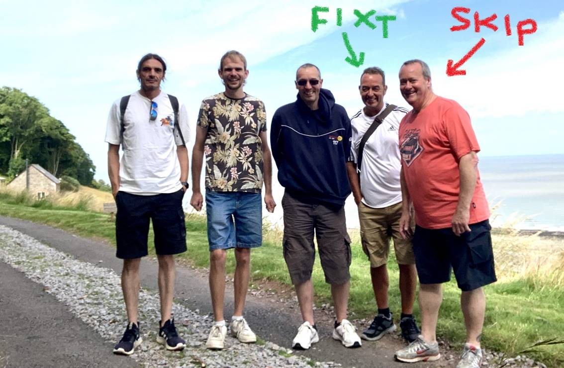 A group of men standing on a road

Description automatically generated