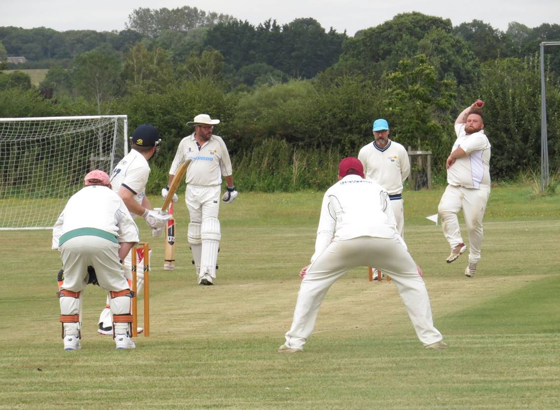 A group of people playing cricket

Description automatically generated