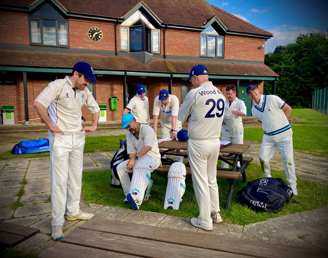 A group of men in white uniforms outside a building

Description automatically generated