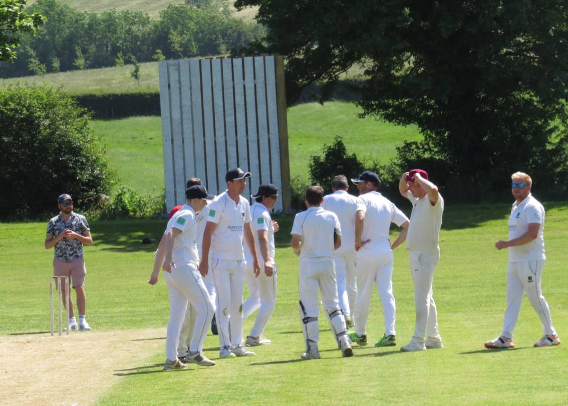 A group of people in white uniforms on a field

Description automatically generated