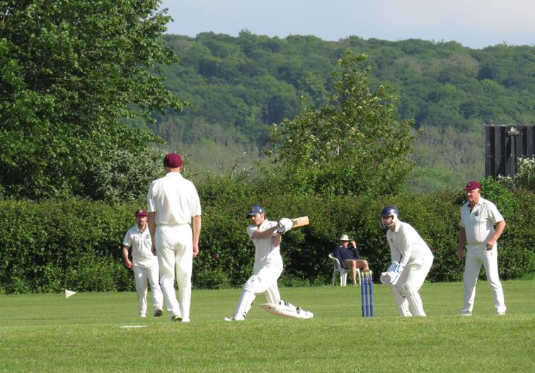 A group of people playing cricket

Description automatically generated