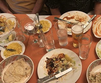 A table with plates of food and glasses

Description automatically generated