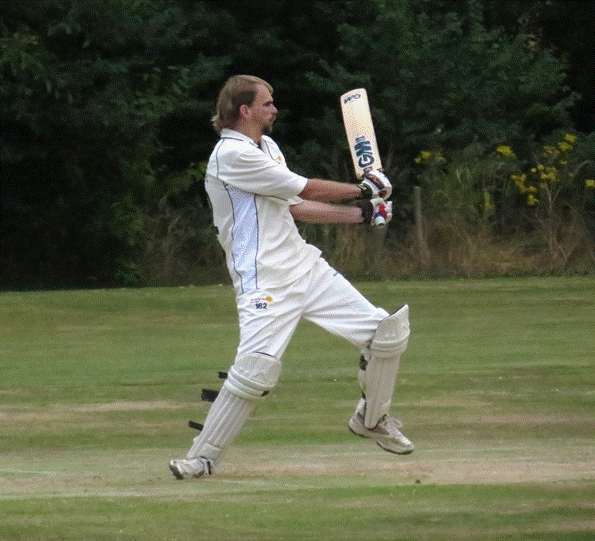 A person in a white uniform holding a bat

Description automatically generated