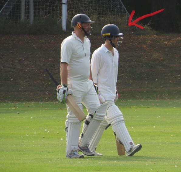 A group of men in white uniforms walking on a field

Description automatically generated